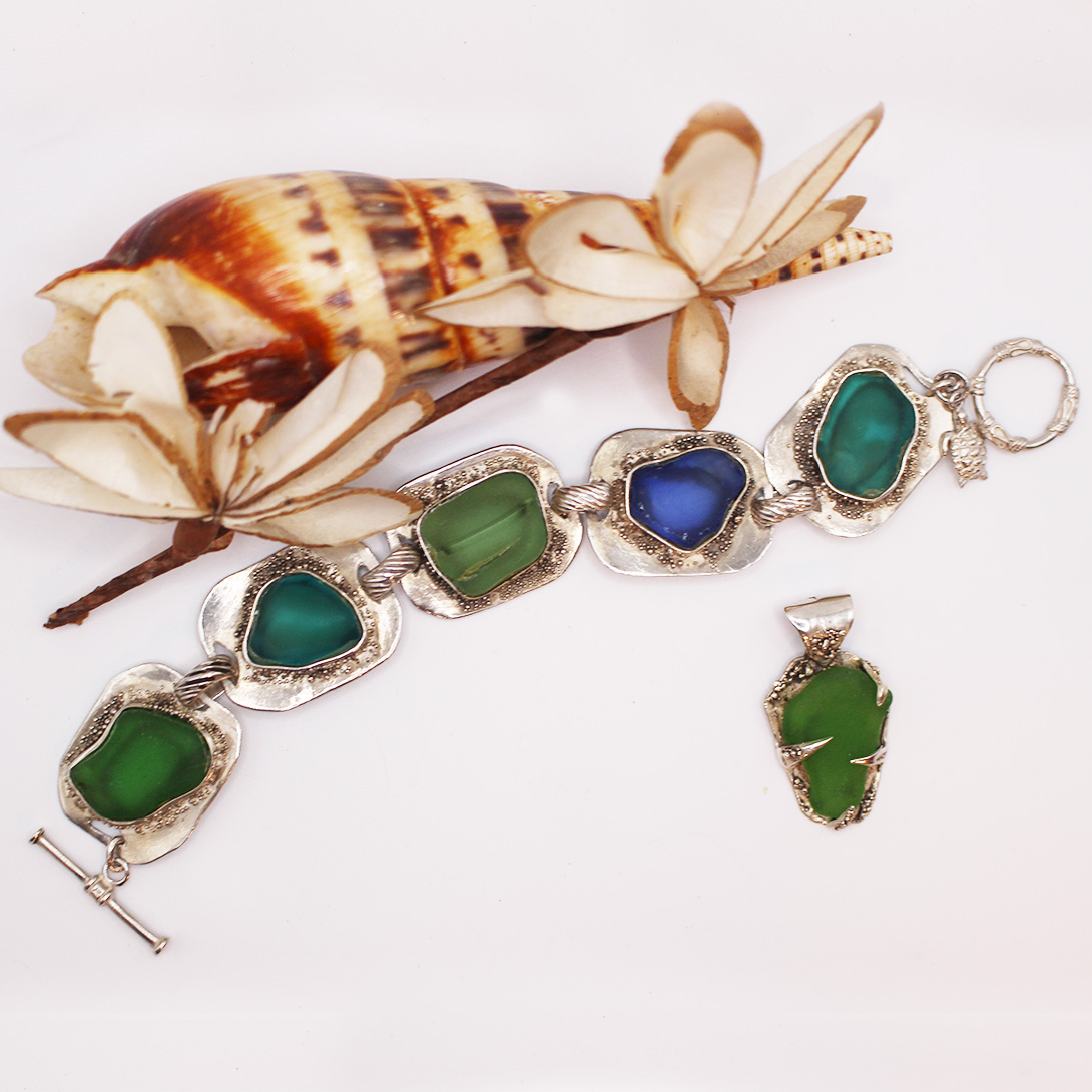 A silver bracelet with seaglass on it.
